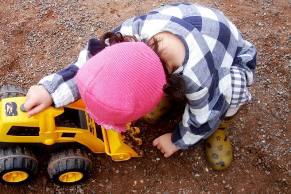 Meisje speelt met graafmachine